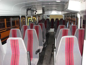 Inside of transit bus with red and grey seats