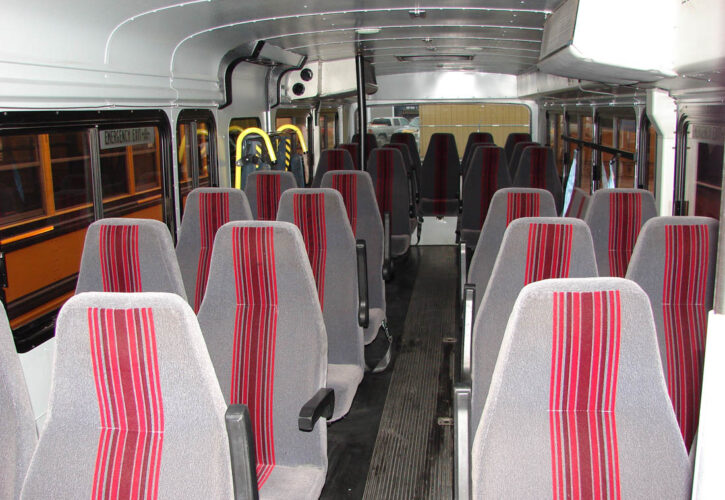 Inside of transit bus with red and grey seats