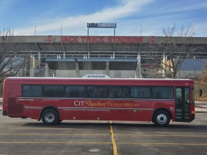 Red CIT Signature Transportation transit bus in front of Jack Trice Stadium