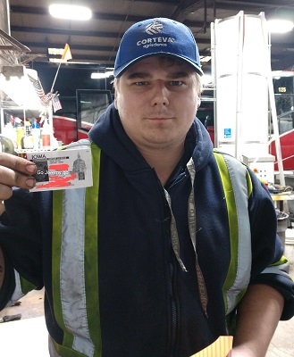 Man in a blue coat with a reflective vest and hat holding a liscence